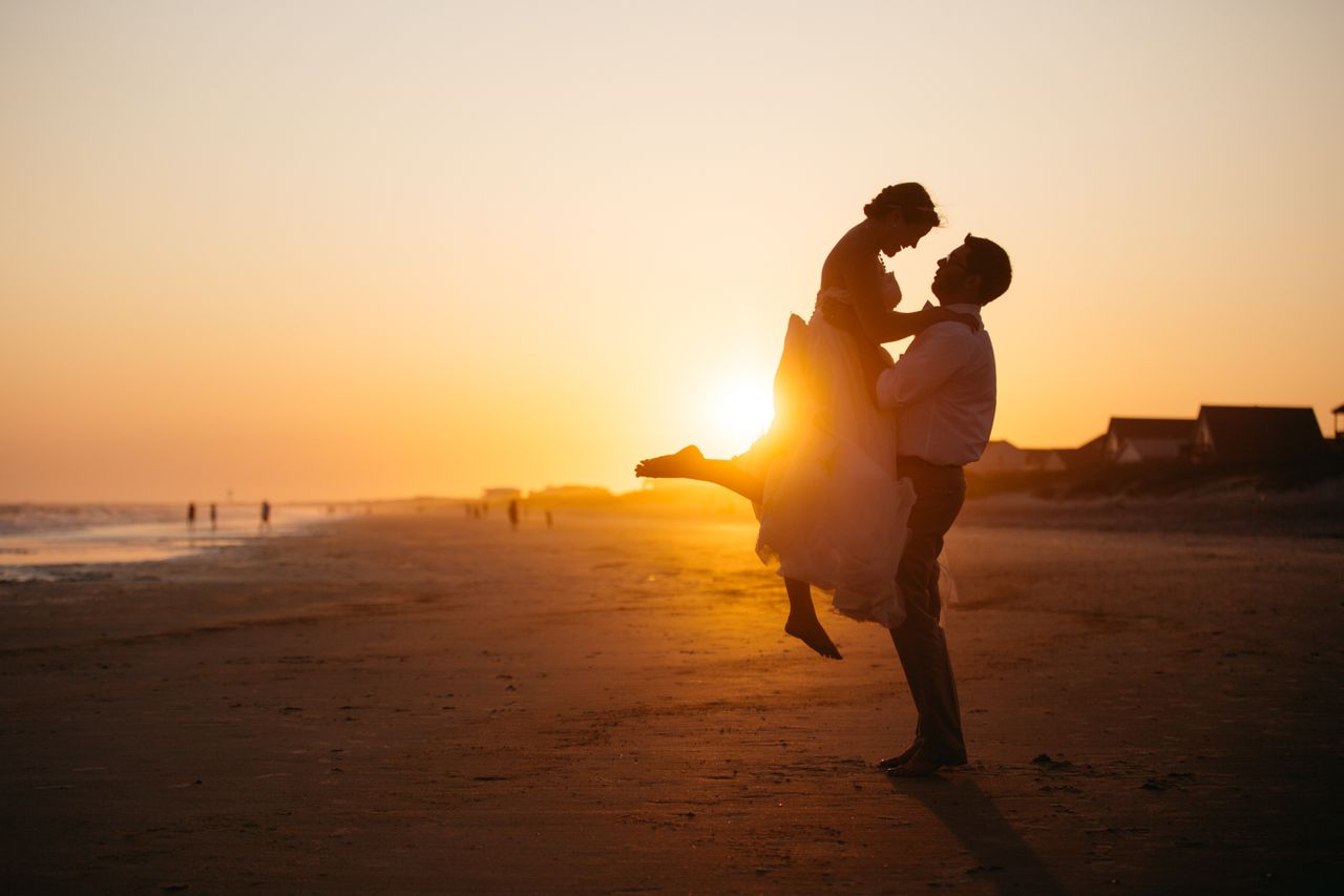 A husband and wife sharing a moment on the at sunset beach after their wedding