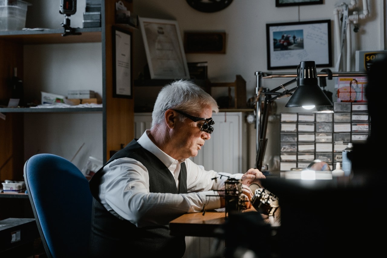 An expert craftsman meticulously working on a watch.