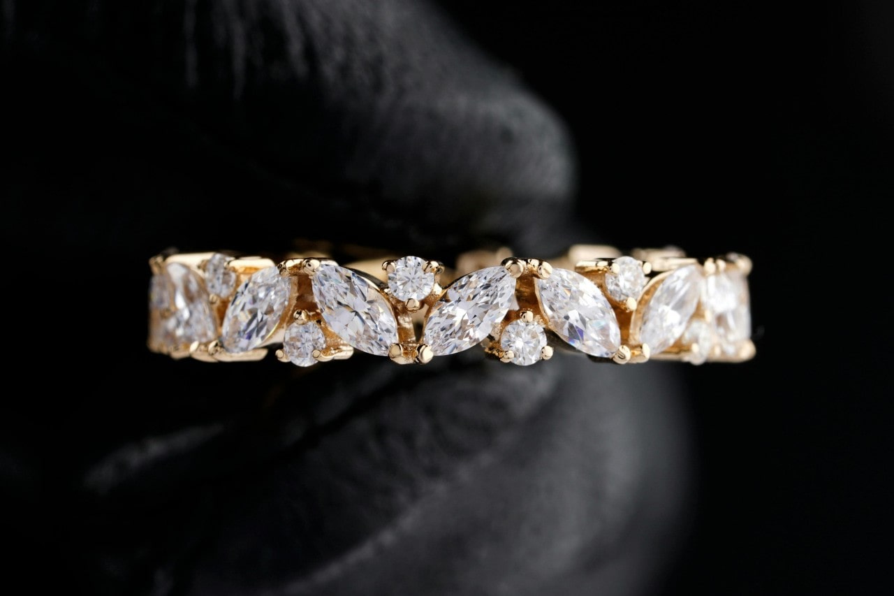 a yellow gold wedding band featuring marquise and round cut diamonds