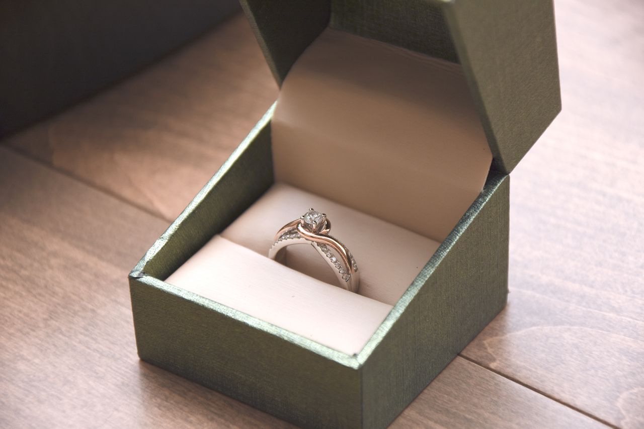 A modern, two tone woman’s engagement ring sits in a box.