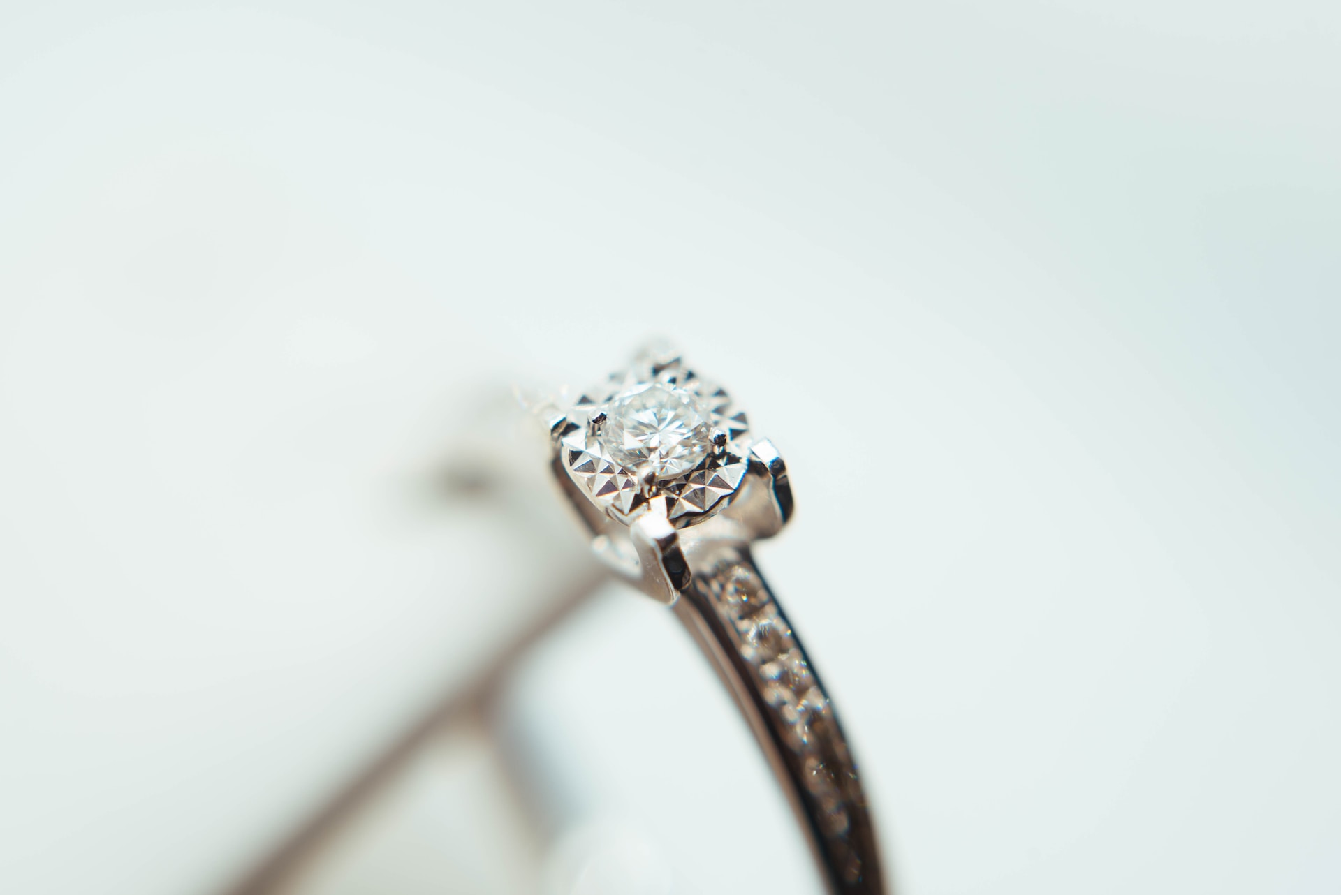 close up image of a round cut engagement ring featuring channel set side stones