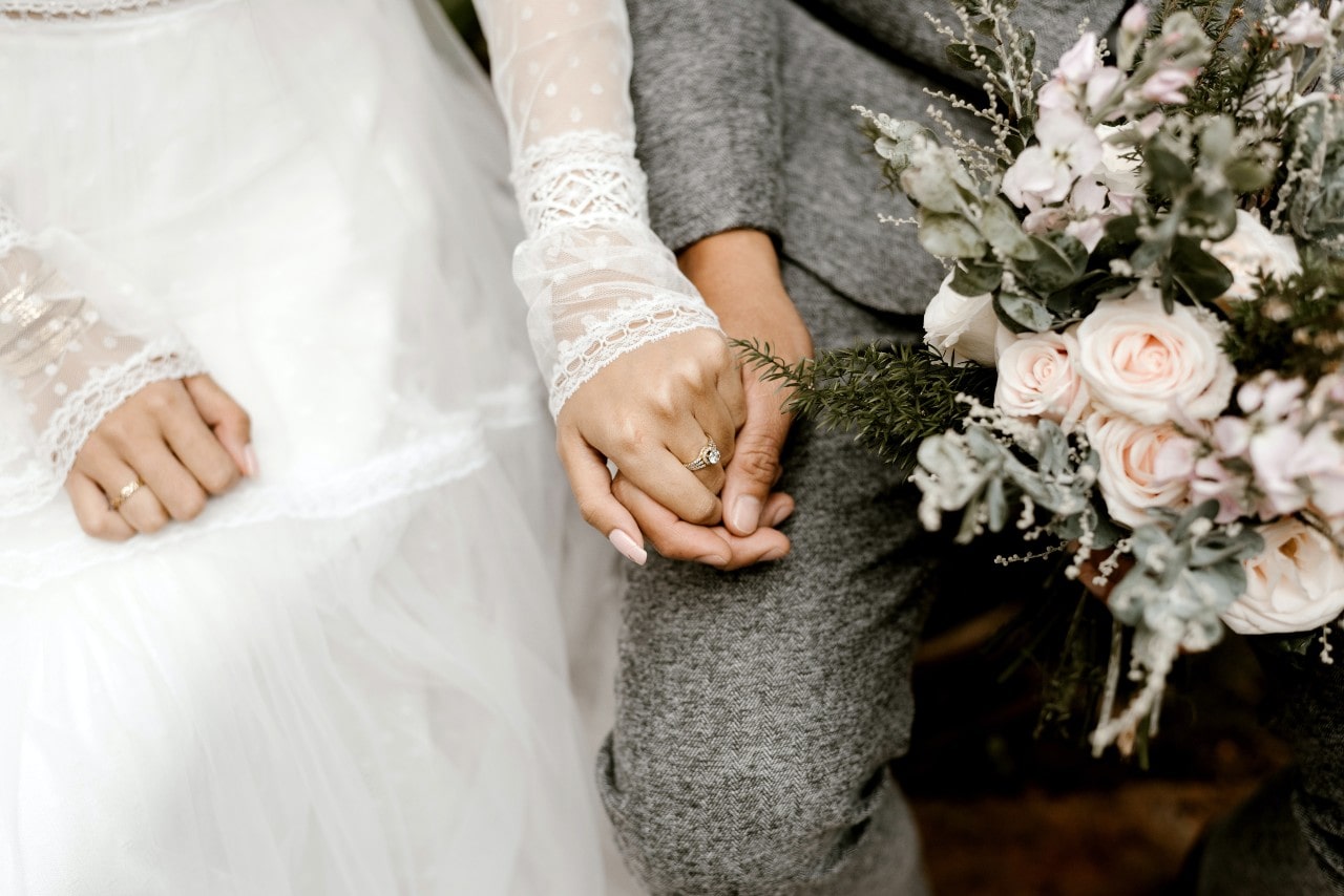 close up image of a person’s hand wearing a solitaire radiant cut engagement ring